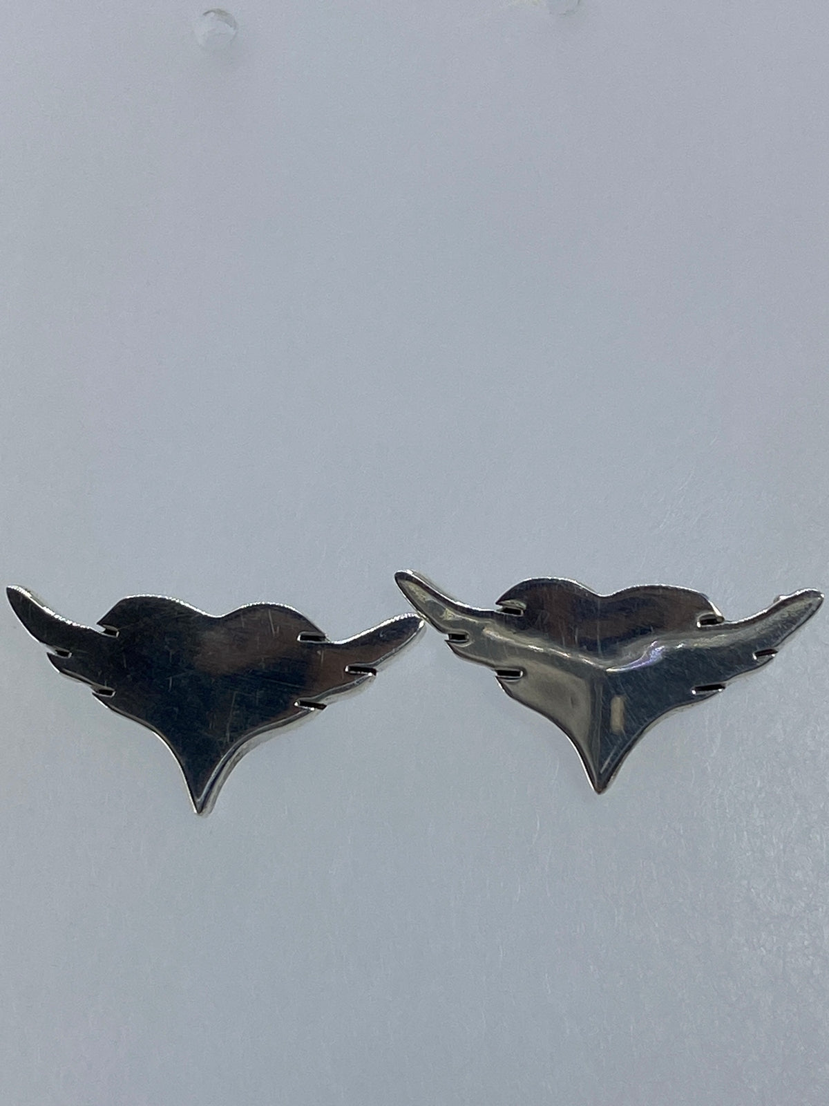 Aretes en la mano mostrando el tamaño delicado de 1.2 cm