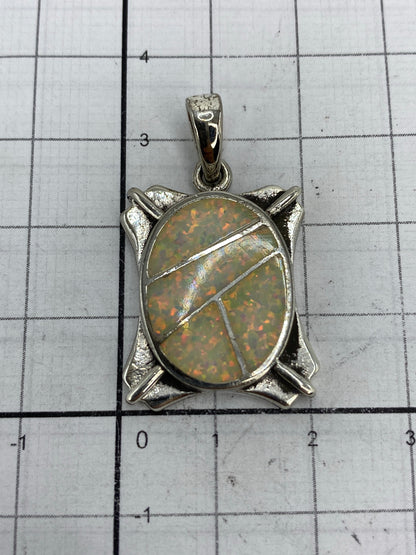 Dije de 3.5 × 2 cm sobre regla — tamaño de pulgar extendido, sin cadena incluida