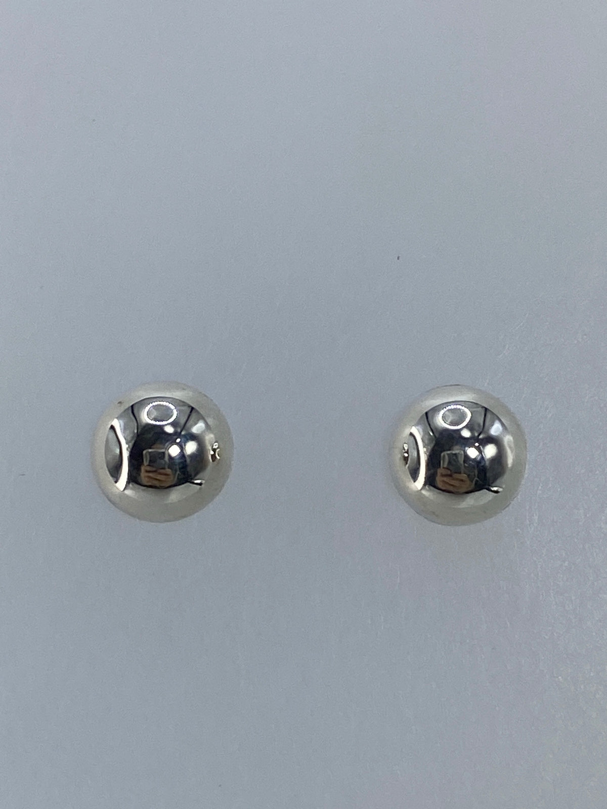 Par de aretes de plata 925 granulado minimalistas en la oreja de una mujer