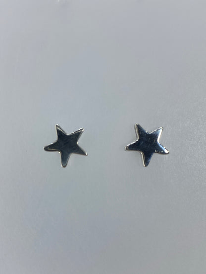 Aretes de plata minimalistas con estrella pulida sobre fondo blanco