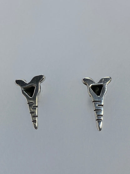 Par de aretes de plata cartoneado con diseño geométrico abstracto, vistos de frente