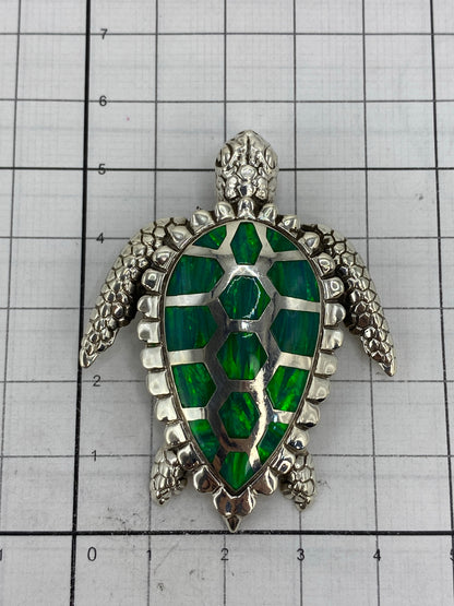 Dije de tortuga sobre escala de centímetros, 5.2 × 4.2 cm