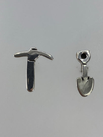 Par de aretes de plata cartoneado en la mano, vista frontal