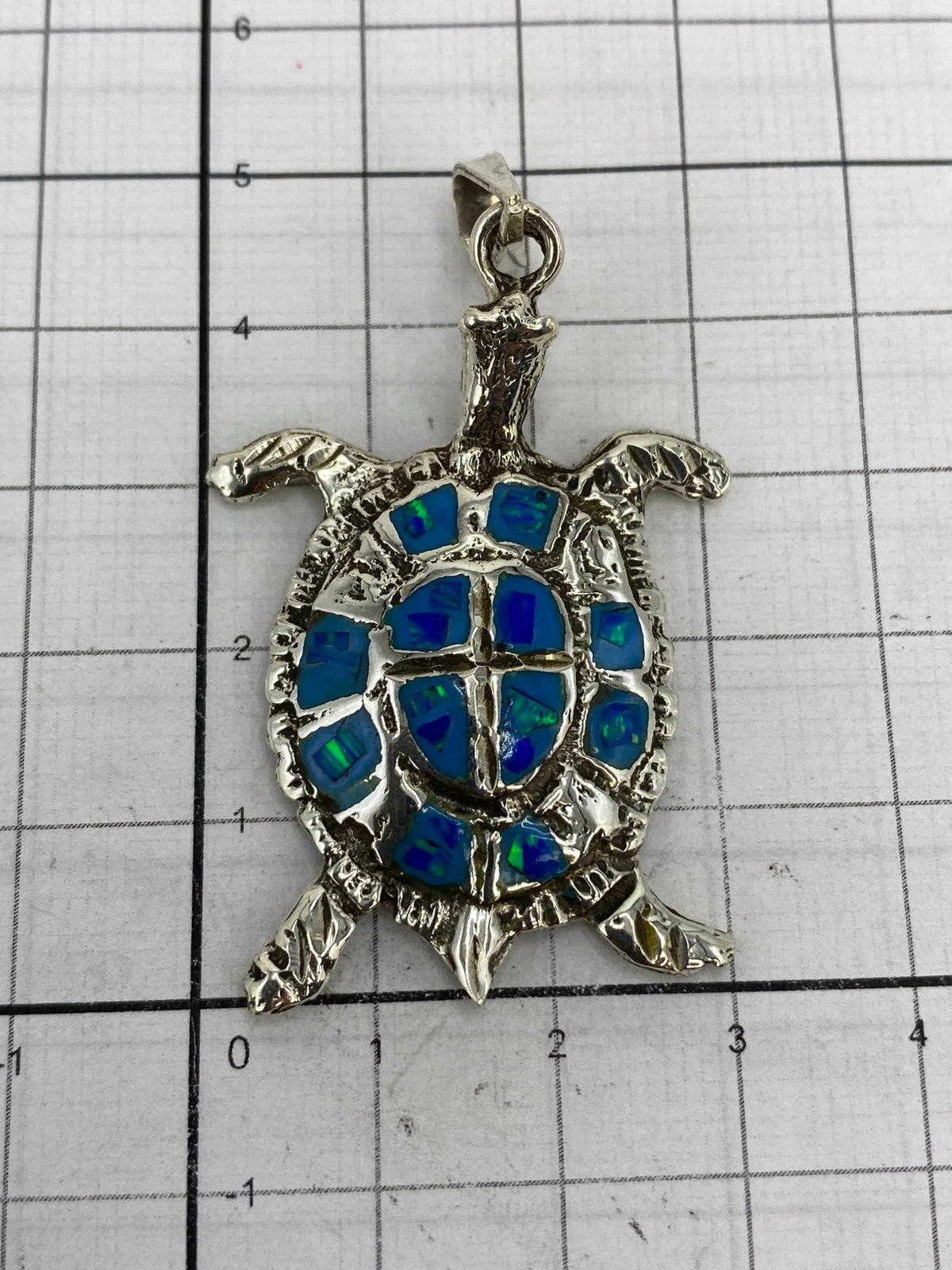 Dije tortuga en la balanza mostrando peso de 13.3 gramos