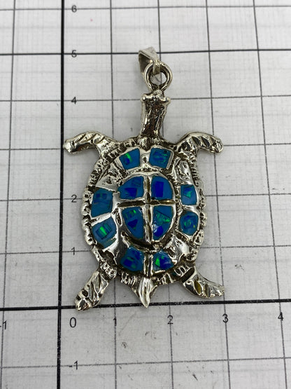 Dije tortuga en la balanza mostrando peso de 13.3 gramos