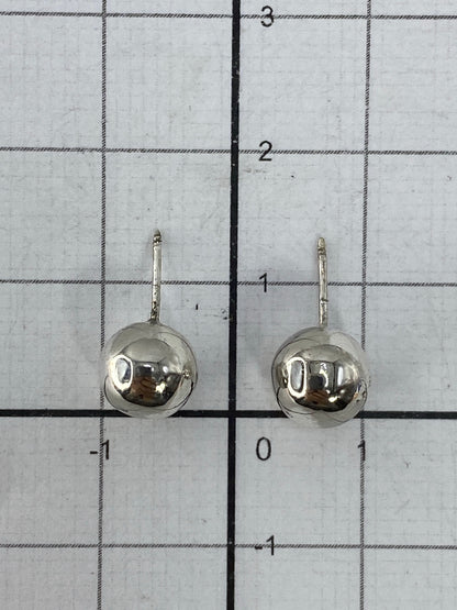 Aretes en la mano mostrando el tamaño minimalista y el peso ligero