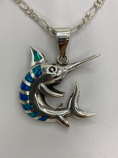 Dije marlin en plata 950 con ópalo de fuego azul, visto de frente