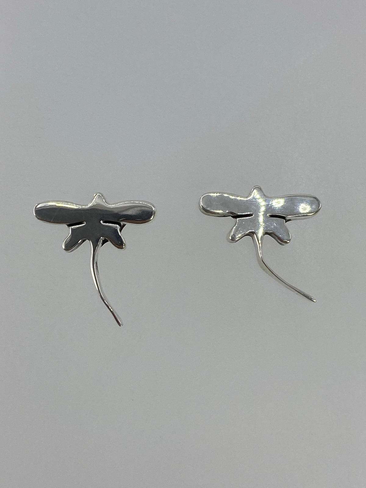 Par de aretes de plata 925 en cartoneado minimalista sobre fondo gris