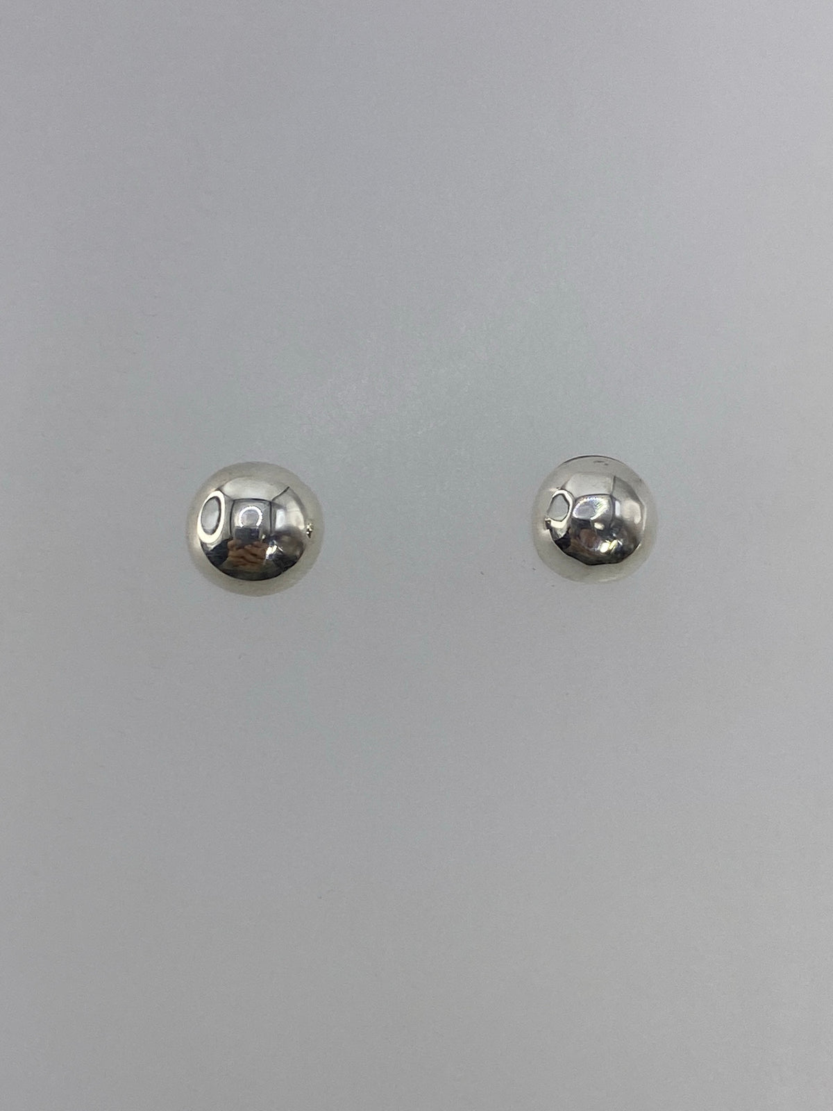 Vista frontal de los aretes minimalistas de plata 925