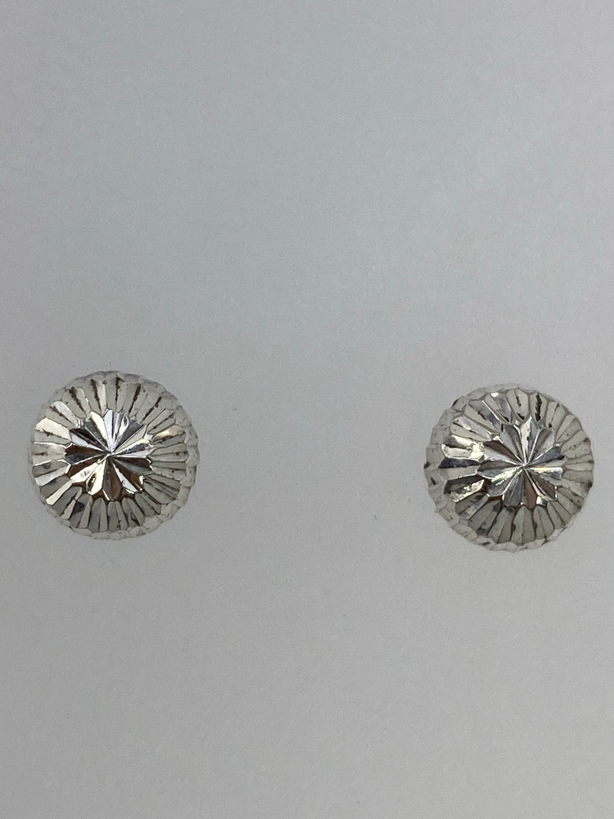 Aretes en poste sobre regla de centímetros, mostrando largo de 1 cm