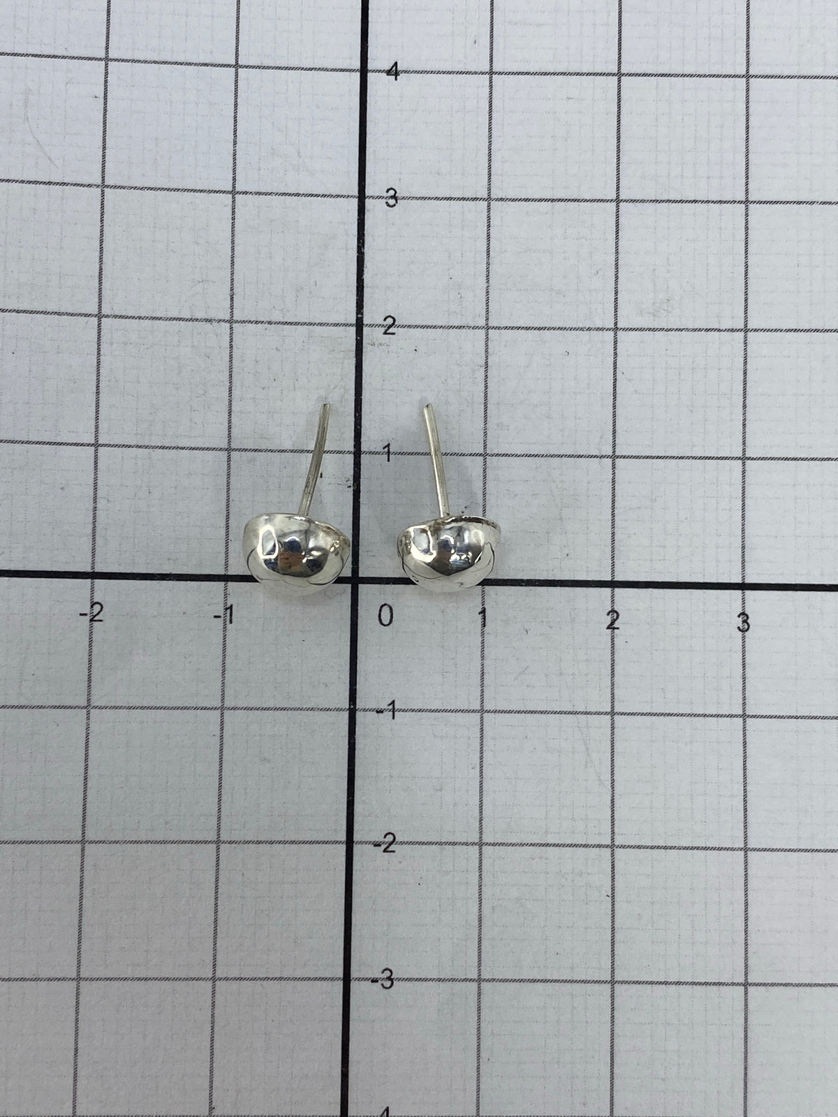 Aretes sobre fondo blanco mostrando el Quinto 925 en el poste