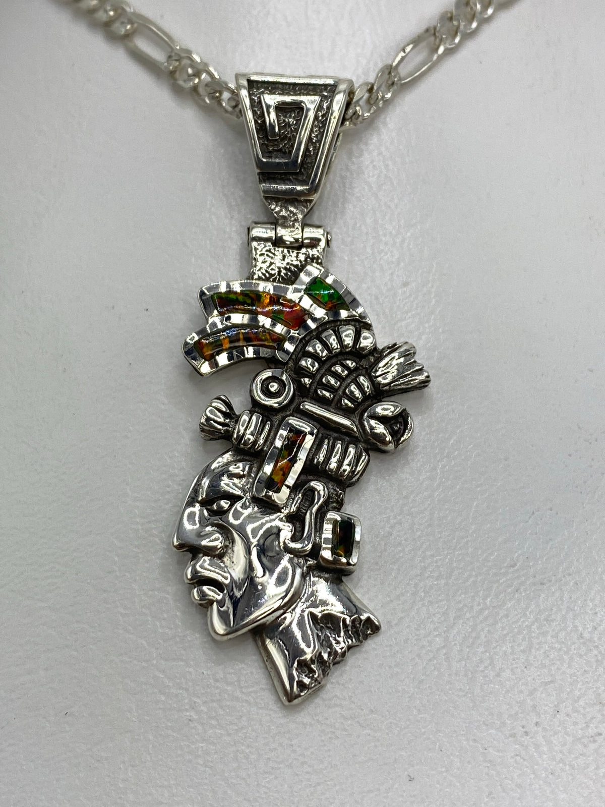 Dije prehispánico de plata 950 con guerrero y ópalo de fuego multicolor, colgante sobre collar plateado