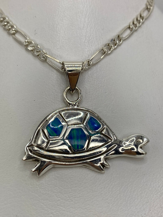 Dije tortuga en plata 925 con ópalo de fuego azul sobre cadena figaro