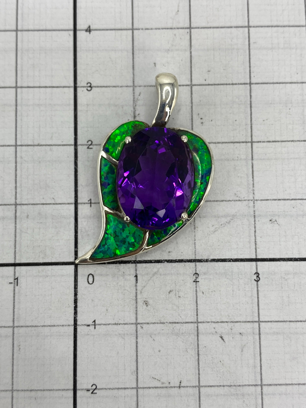 Medida del dije comparada con escala: 3.4 cm de largo × 1.3 cm de ancho