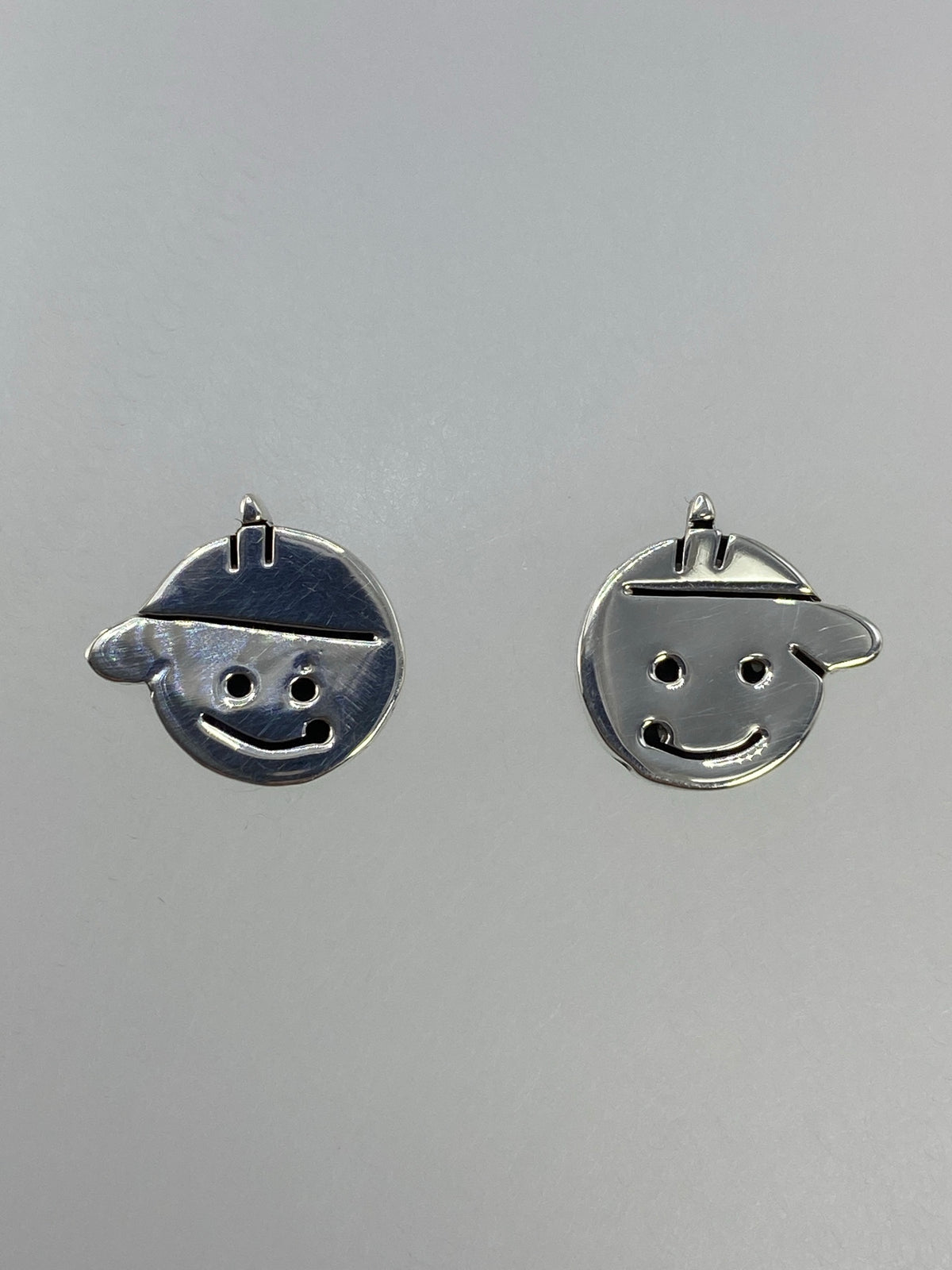 Par de aretes de plata 925 con carita sonriente y gorro, vista frontal