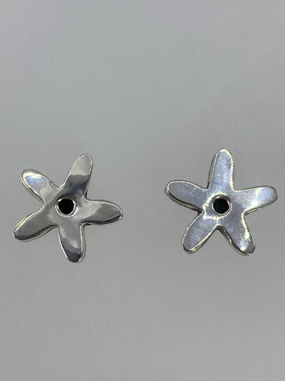 Aretes de plata 925 colocados sobre una regla mostrando 1.5 cm de largo