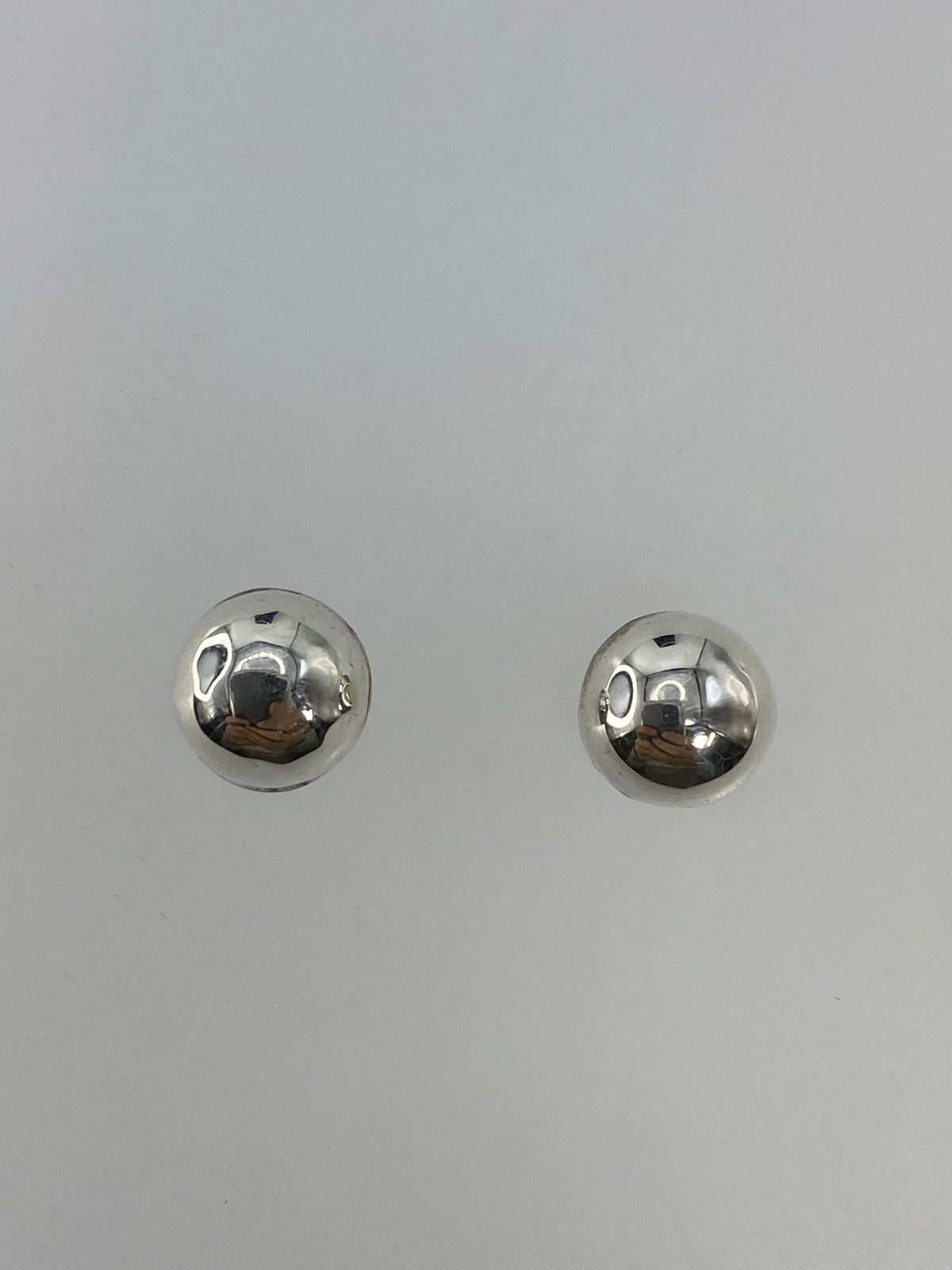 Detalle de los dos aretes de plata 925 con postes y cierre de mariposa