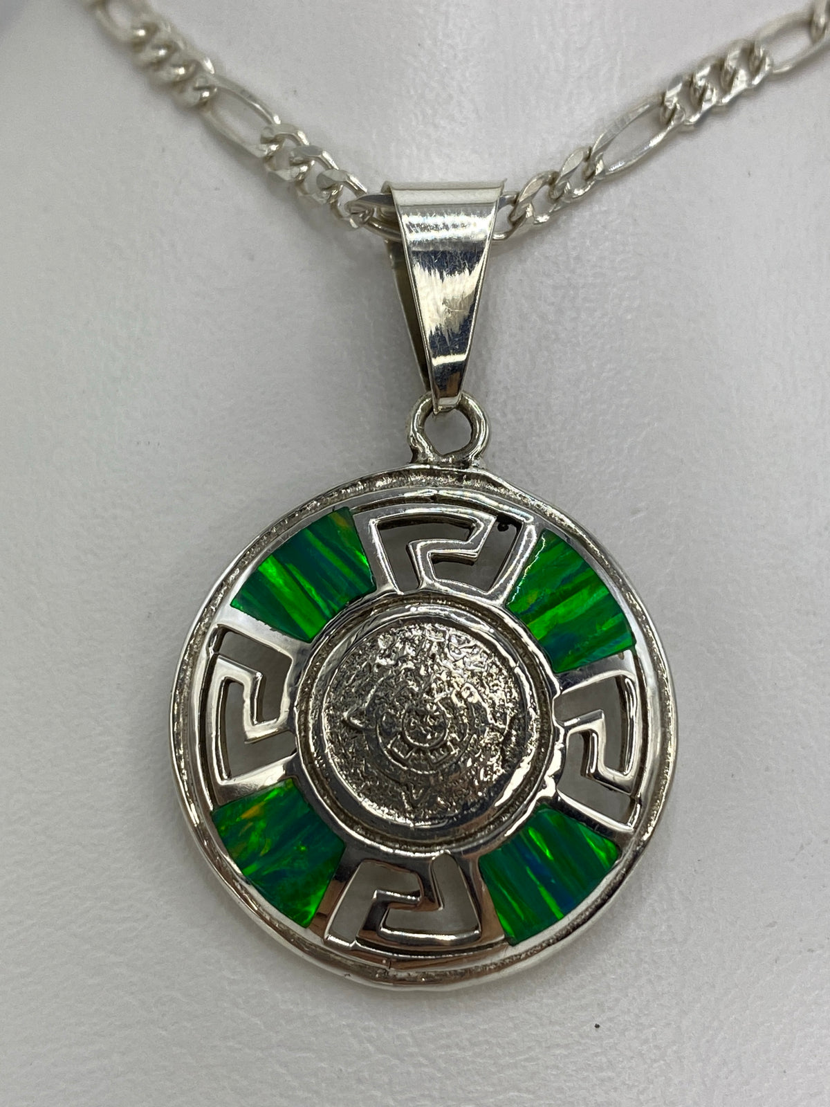 Dije de plata con Calendario Azteca y ópalo de fuego verde engastado, colgando de cadena plateada