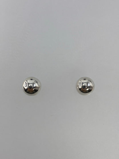 Detalle de los aretes de cartoneado mostrando la precisión de la esfera de plata 925