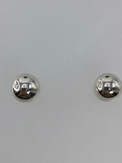 Aretes sobre escala digital mostrando el peso mínimo de 0.7 gramos el par