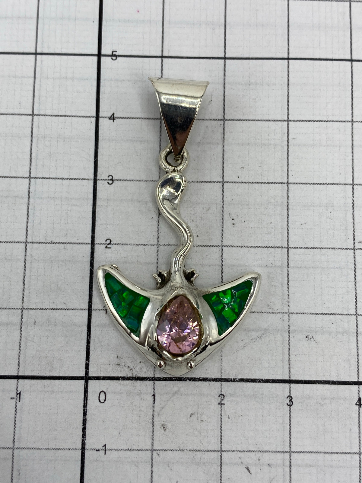 Medida del dije sobre regla: 4.5 cm de largo × 2.4 cm de ancho