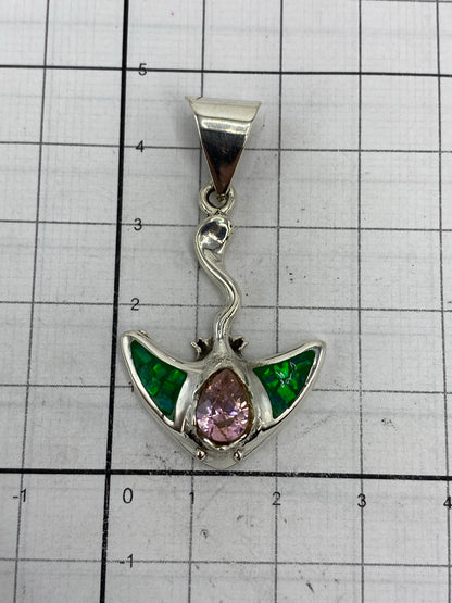 Medida del dije sobre regla: 4.5 cm de largo × 2.4 cm de ancho