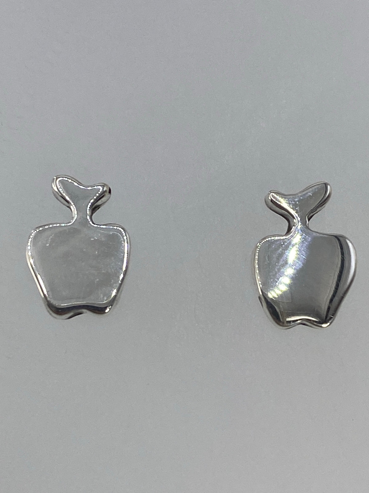 Aretes puestos en oído, mostrando el tamaño y acabado de 1.2 cm