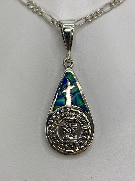 Dije de plata 950 con cruz y símbolo prehispánico, ópalo de fuego azul, sobre cadena figaro