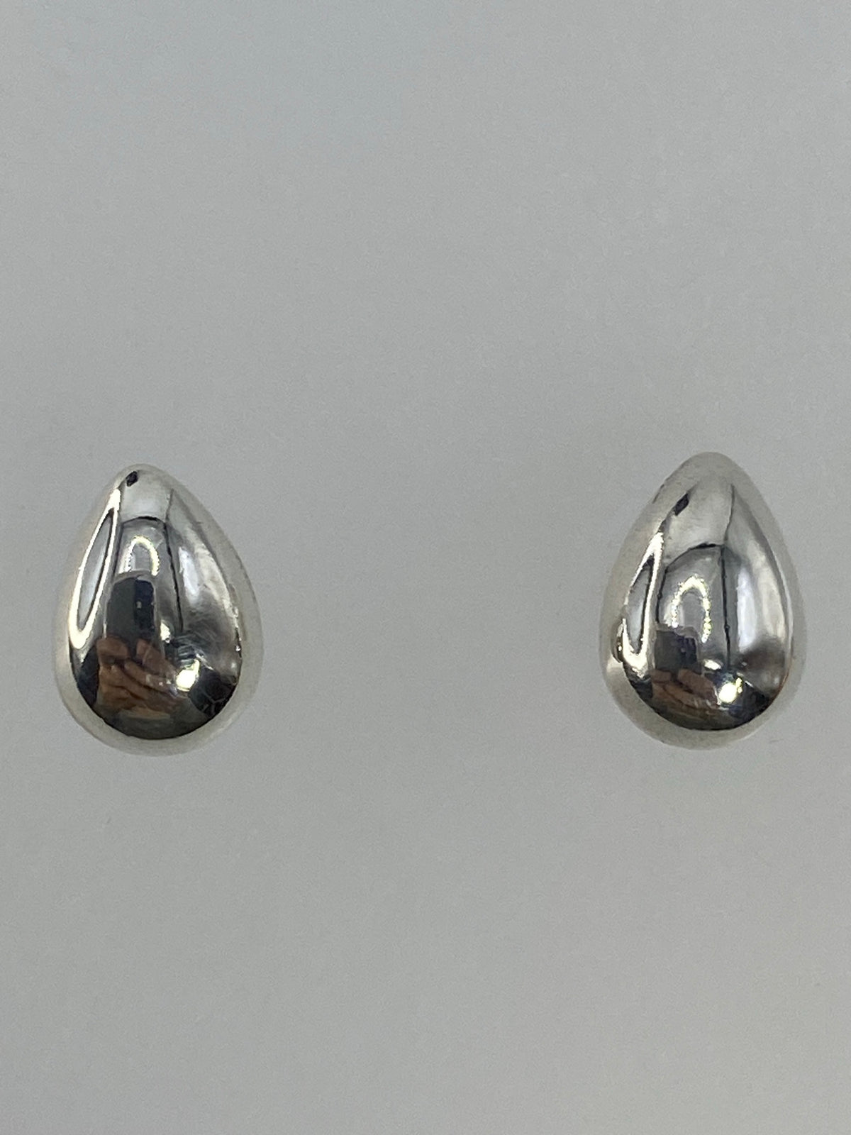 Aretes en escala con regla, midiendo 1.5 cm de largo