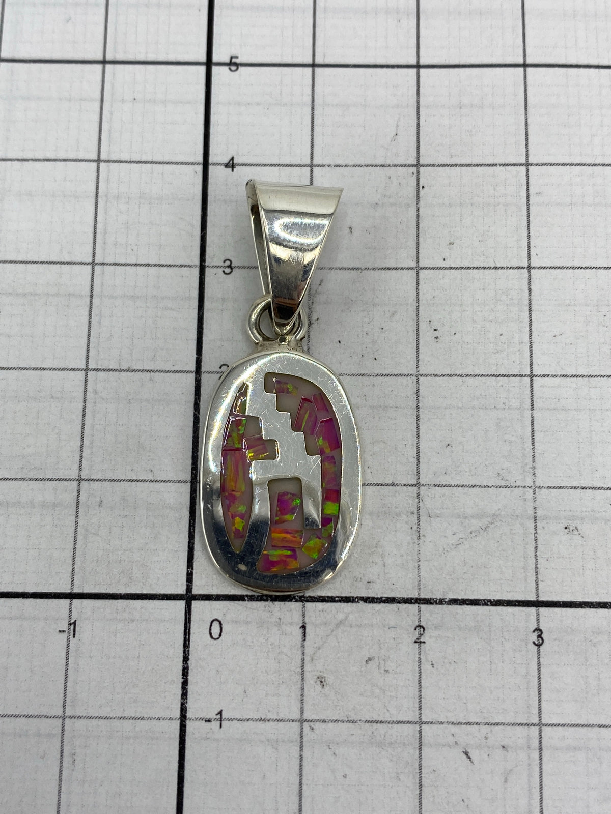 Medida del dije (3.7 cm × 1.4 cm) en regla para mostrar tamaño compacto