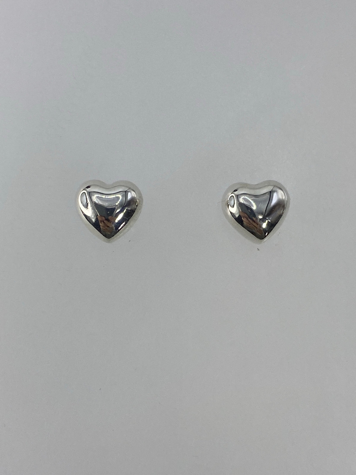 Detalle de un arete de plata mostrando el acabado cartoneado de la bola