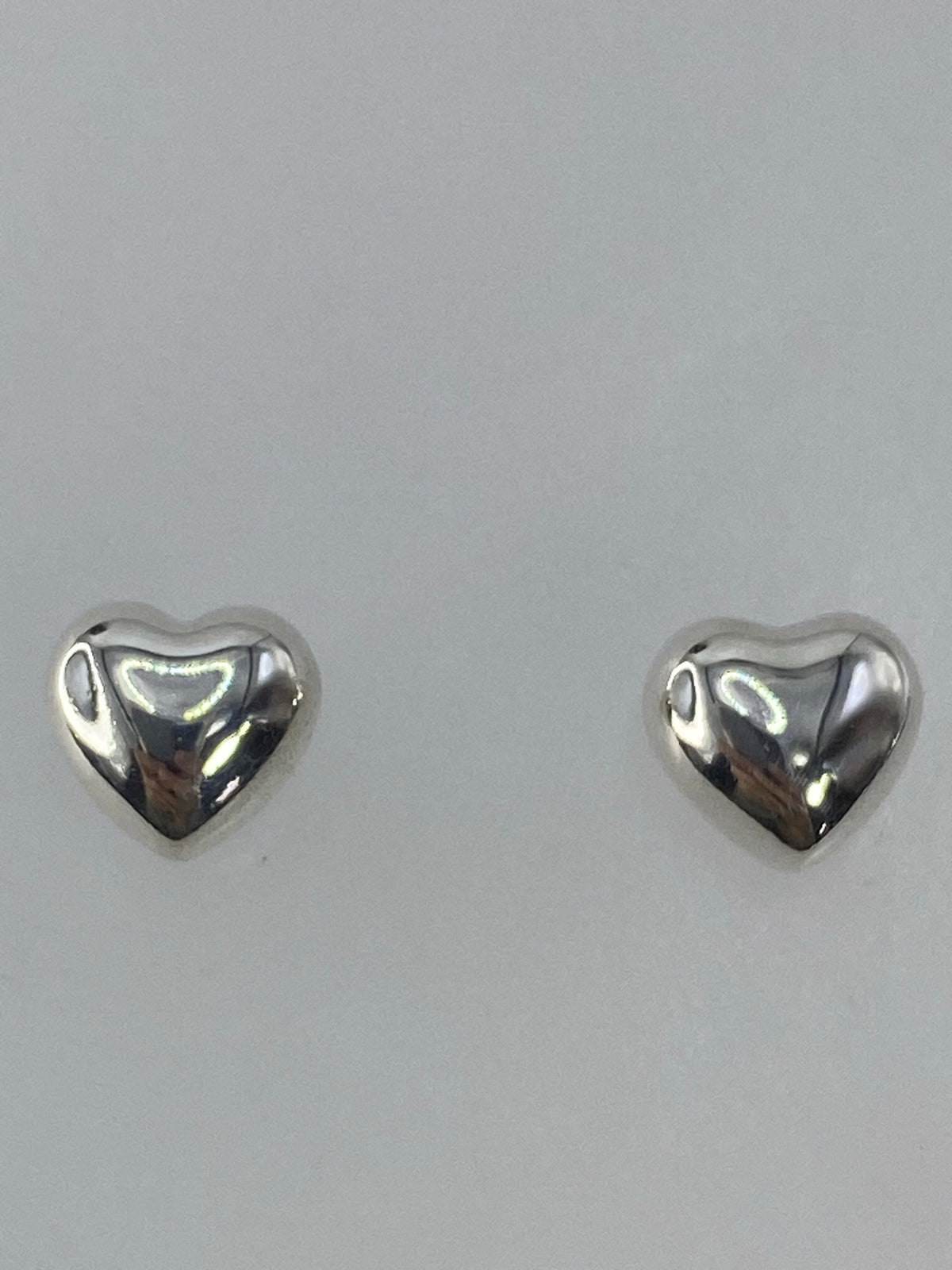 Los dos aretes juntos sobre una regla de centímetros, midiendo 1.8 cm de largo