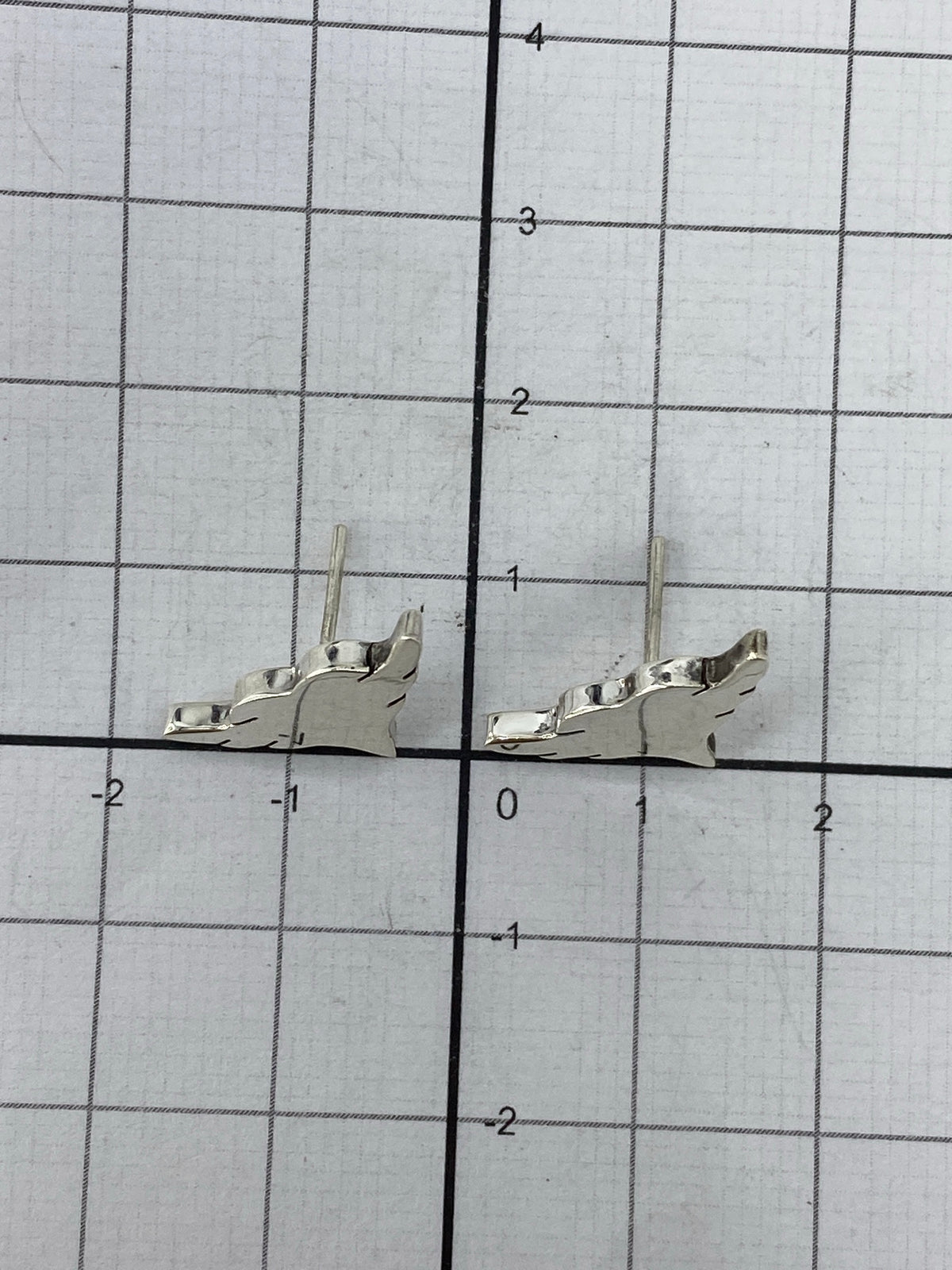 Aretes en la mano mostrando el peso ligero y el acabado pulido