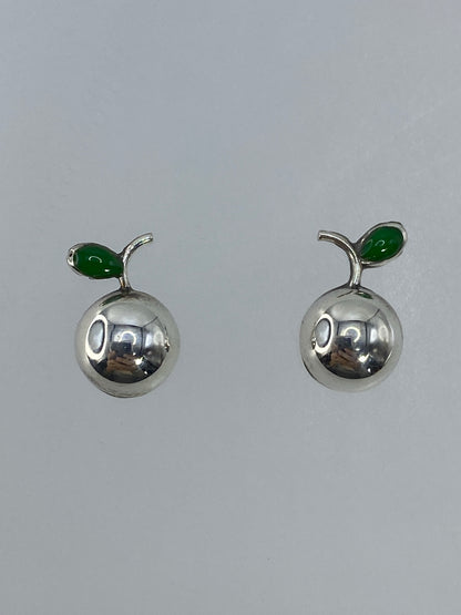 Aretes pequeños de plata cartoneado del tamaño de una perla sobre fondo blanco