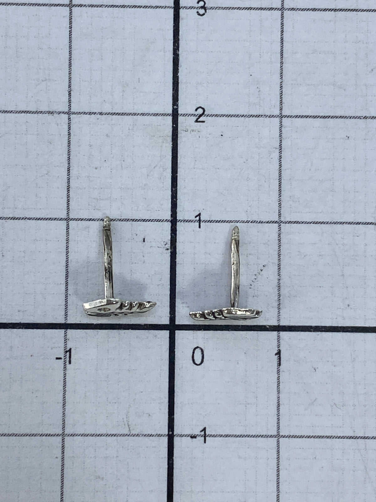 Aretes de plata cartoneado con cierre de poste sobre fondo blanco mostrando el volumen en 3D