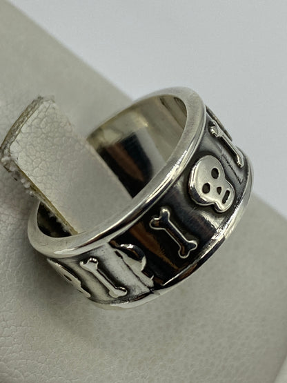 Anillo repujado Calavera puesto en dedo, mostrando el relieve y el oscurecimiento del metal