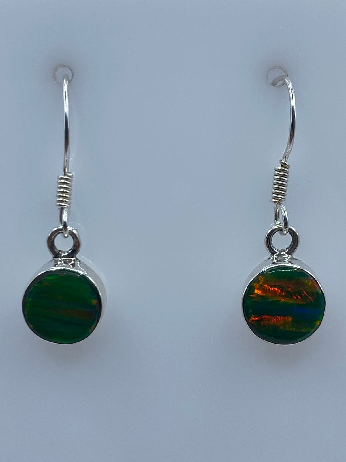 Par de aretes de plata con ópalo de fuego verde limón colgando, vista frontal