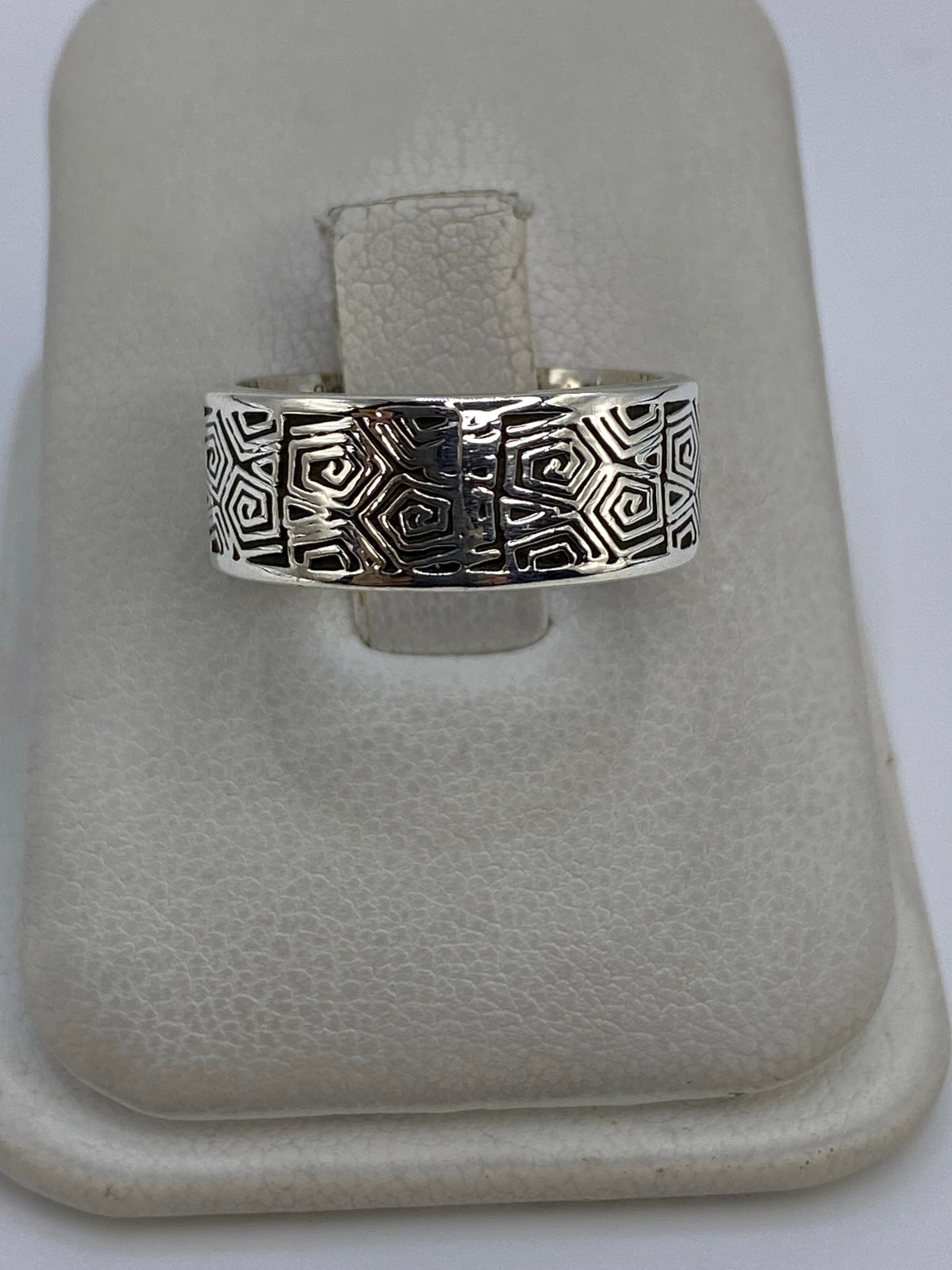 Anillo de plata con motivos geométricos prehispánicos en la mano