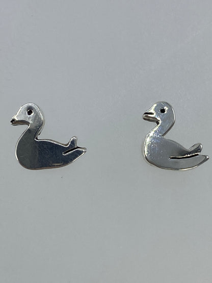 Aretes sobre fondo gris claro mostrando el tamaño real (1 cm)