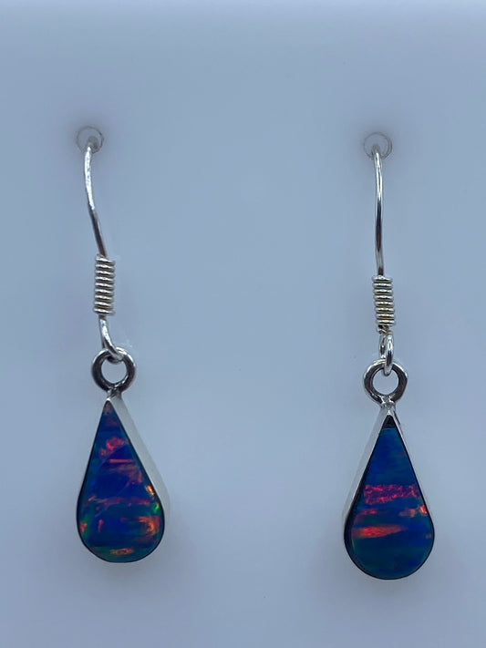 Aretes de plata con opalo de fuego azul, par completo sobre fondo blanco
