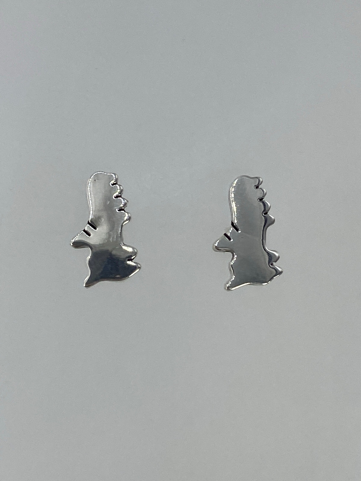 Detalle lateral de los aretes de plata cartoneada en Taxco