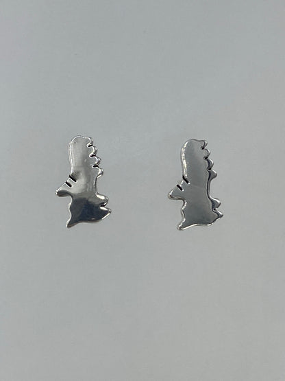 Detalle lateral de los aretes de plata cartoneada en Taxco