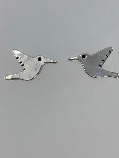 Aretes de cartoneado de plata sobre una mano, mostrando ligereza y detalle