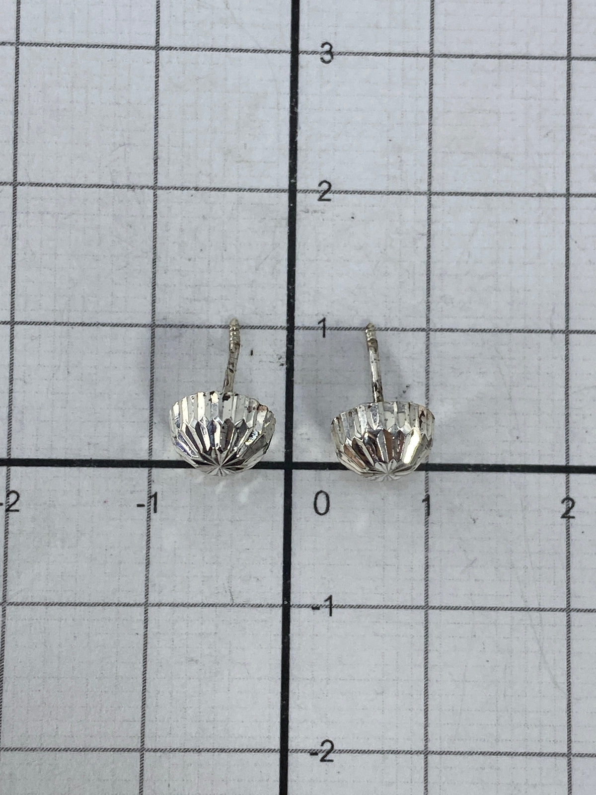 Aretes sobre fondo blanco mostrando el tamaño real de 1 cm