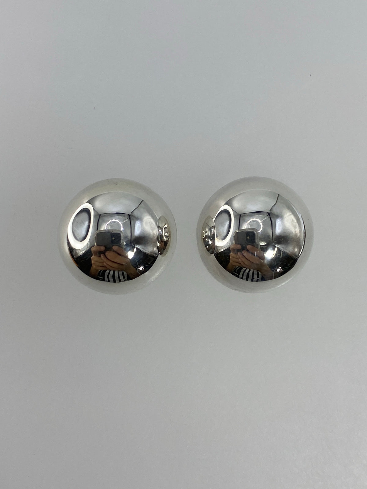 Vista frontal de los aretes esféricos de plata pulida brillo