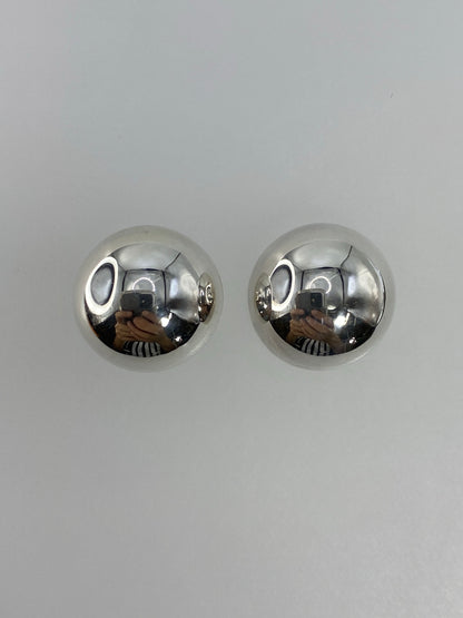 Vista frontal de los aretes esféricos de plata pulida brillo