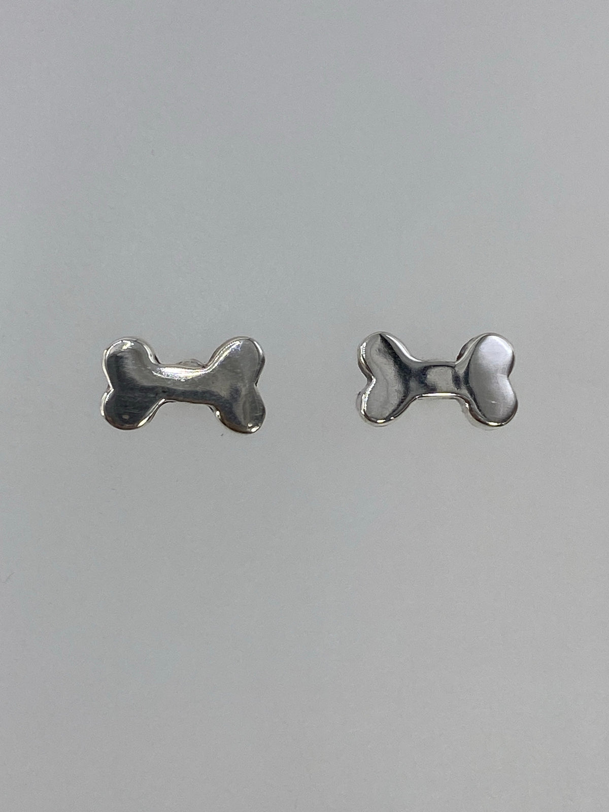 Par de aretes de plata 925 en forma de lazo, cartoneado, vista frontal minimalista