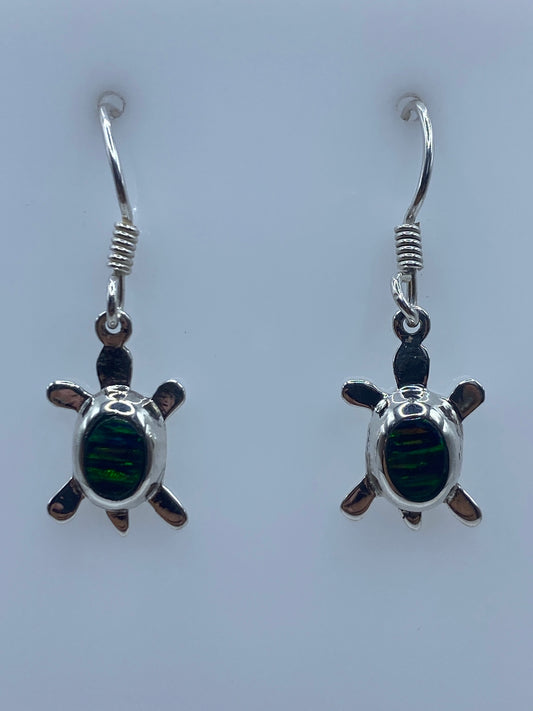 Par de aretes de plata con forma de tortuga y ópalo de fuego en los oídos