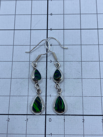 Reverso de los aretes con marca del Quinto 925, sobre fondo gris