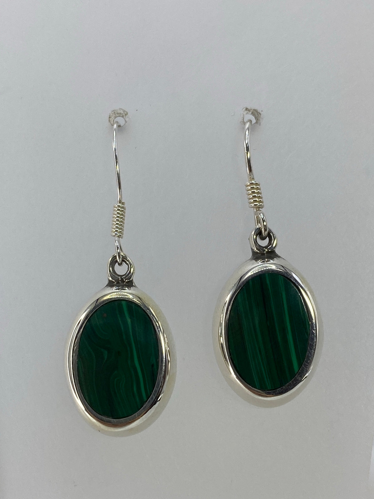 Aretes de plata con incrustación de piedra verde, vista detallada del engaste a mano